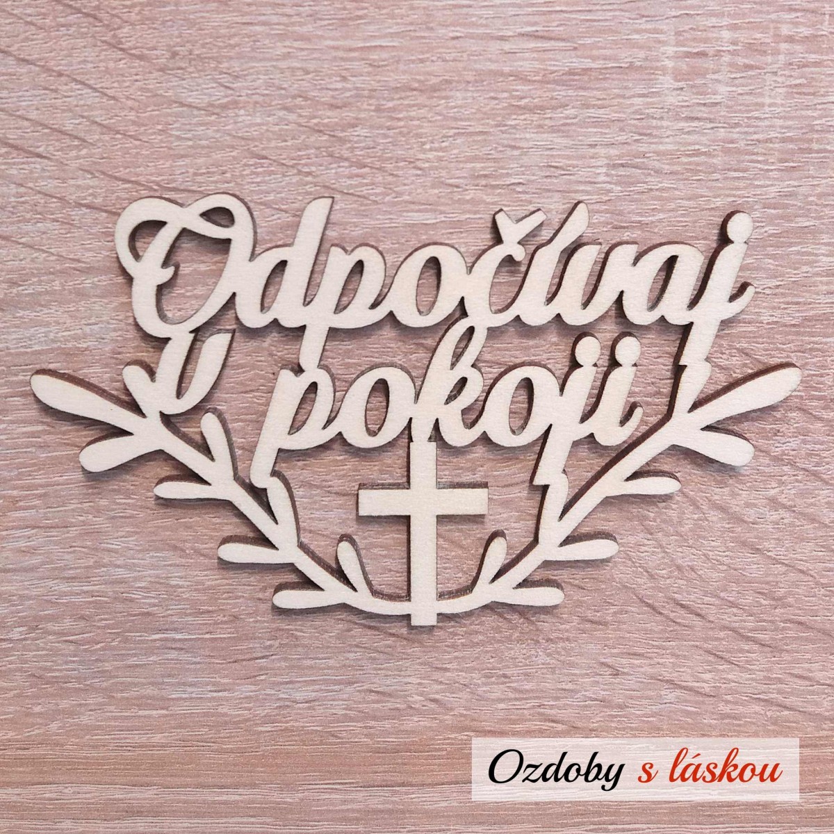 Drevený nápis Odpočívaj v pokoji s krížikom a vetvičkami na Sviatok Všetkých svätých.