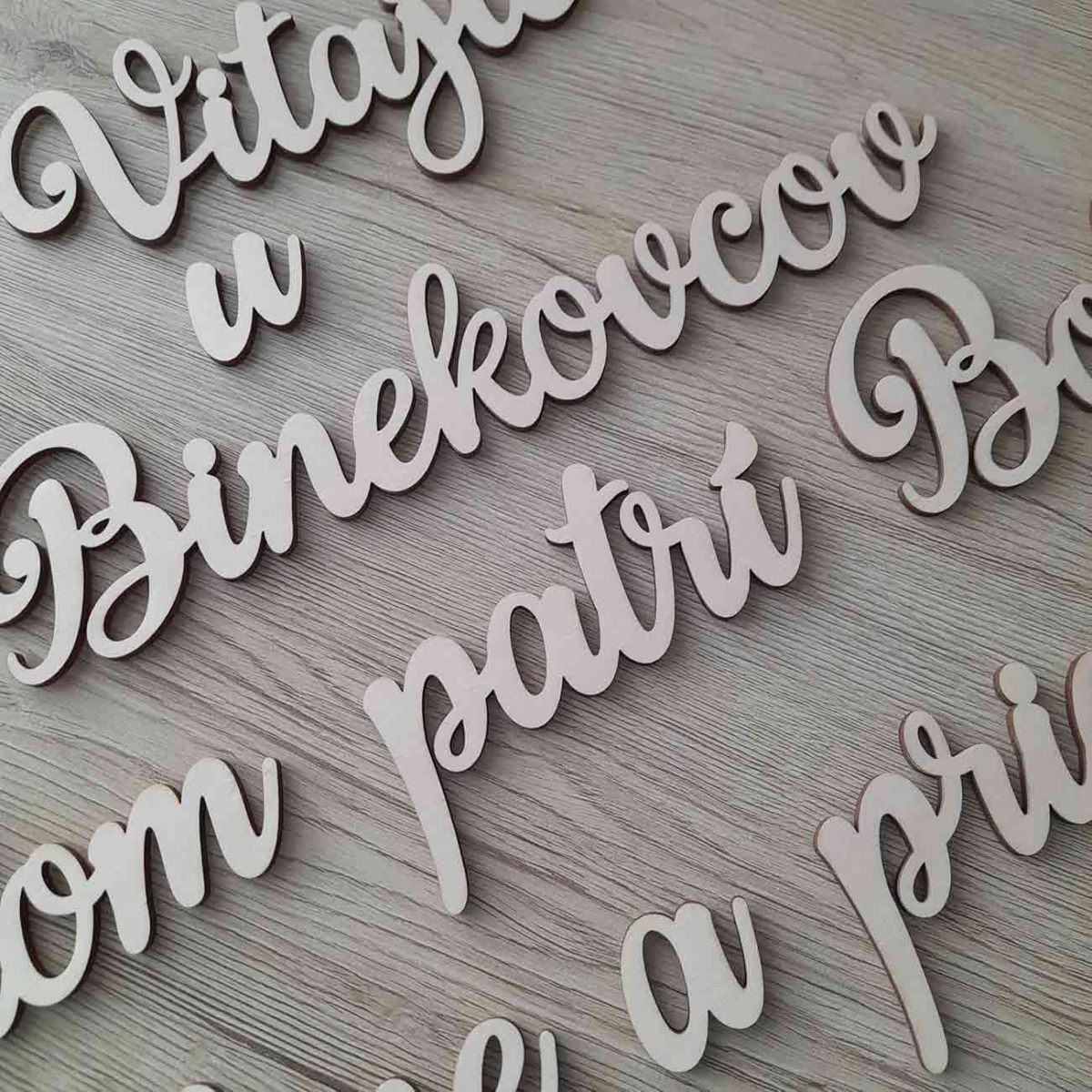 Detail dreveného nápisu na stenu s vlastným textom vyrezaného laserom po slovách z preglejky