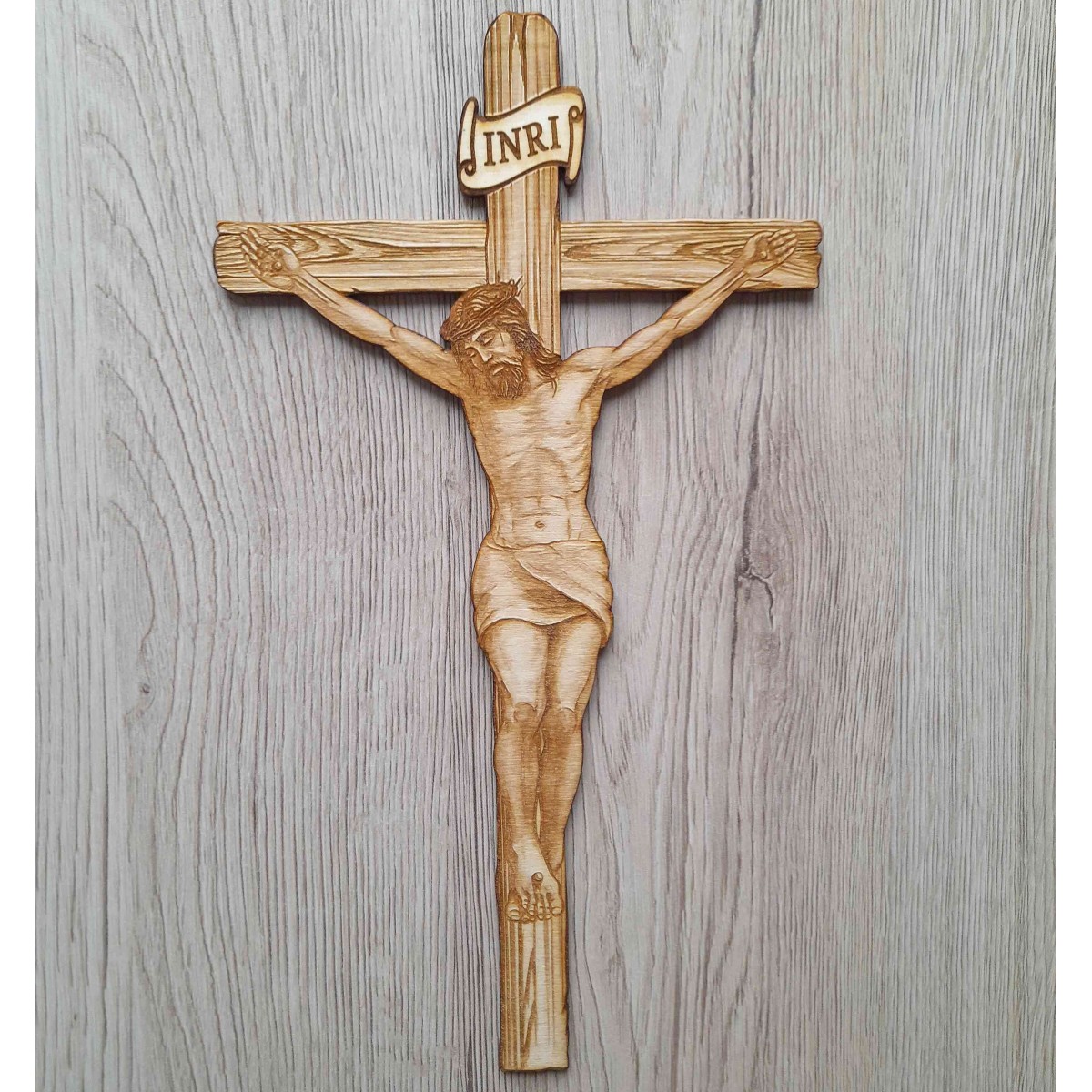 Drevený závesný kríž gravírovaný a vyrezávaný laserom z preglejky s námetom Ježiša na kríži