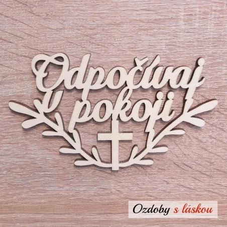 Drevený nápis Odpočívaj v pokoji s krížikom a vetvičkami na Sviatok Všetkých svätých.