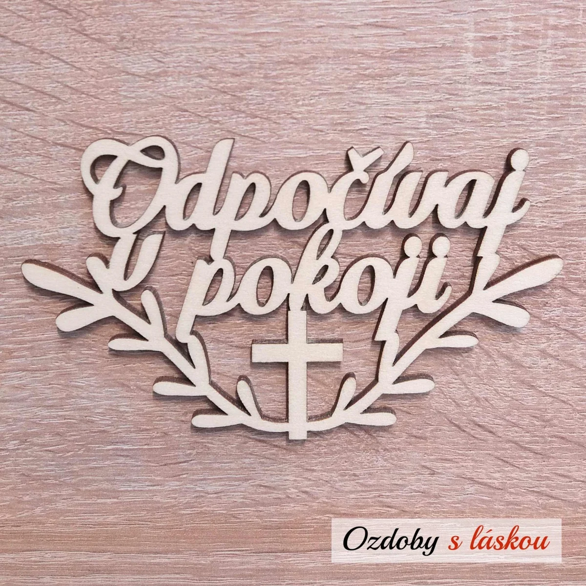 Drevený nápis Odpočívaj v pokoji s krížikom a vetvičkami na Sviatok Všetkých svätých.