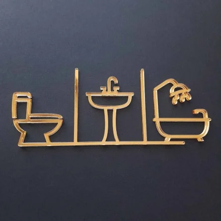 Piktogram na označenie dverí zložený zo symbolu WC, umývadla a kúpeľne vyrezávaný laserom zo zlatého zrkadlového plexiskla
